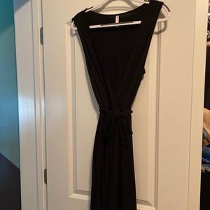 Solid black ribbed jumpsuit with pockets. Deep cross front. Tie waist